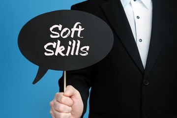 Soft Skills. Businessman holds speech bubble in his hand. Handwritten Word/Text on sign.