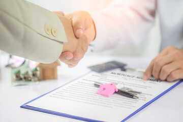 Real estate broker and customer shaking hands after signing a contract: real estate, home loan and concept for mortgage and real estate investment.