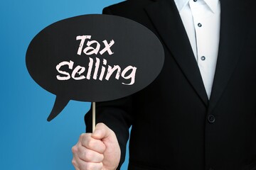 Tax Selling. Businessman holds speech bubble in his hand. Handwritten Word/Text on sign.