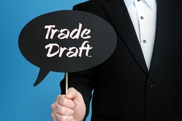 Trade Draft. Businessman holds speech bubble in his hand. Handwritten Word/Text on sign.