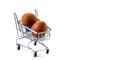 Fototapeta na wymiar Mini trolley with two eggs isolated on white background, shopping and food purchases concept. Copy space for text