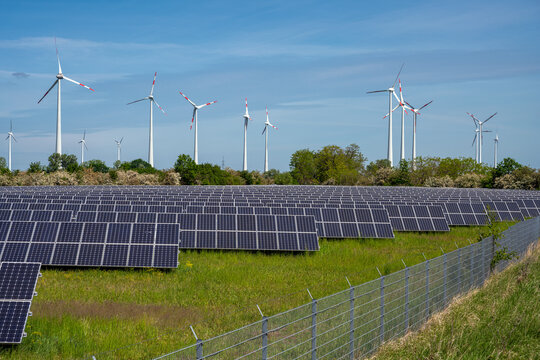 Solar energy panels with wind turbines in the back seen in Germany