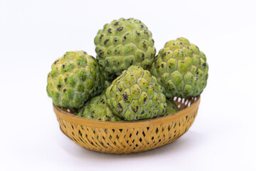Fresh green Custard apples kept on a wooden basket with white background
