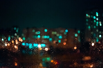 Obraz na płótnie Canvas Colorful city lights behind rainy window glass. Bokeh. Bacground.