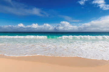 Tropical beach with warm sand and turquoise wave on the sea in paradise island. Tropical beach background.