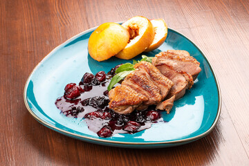 Magre duck breast with baked apple and berry sauce. On a decorative plate
