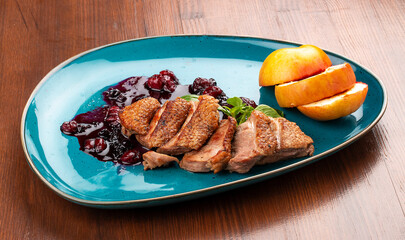 Magre duck breast with baked apple and berry sauce. On a decorative plate
