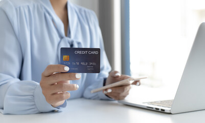 Women use smart phone to register online purchases using credit card payments.