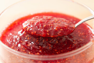 Raspberry jam in a glass cup. Close-up