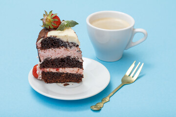 Piece of homemade chocolate cake with fresh strawberries and cup of coffee