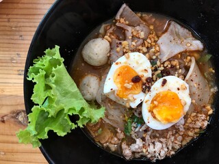 Spicy tom yam noodle soup with boiled egg, pork and big