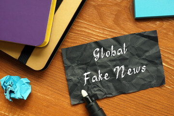 Business concept about Global Fake News with inscription on the sheet.