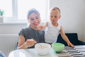 Morning breakfast with the baby. Mother feeds the child with breakfast.