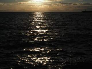 Dramatic sunset over Pacific ocean in winter with sunlight reflecting on water