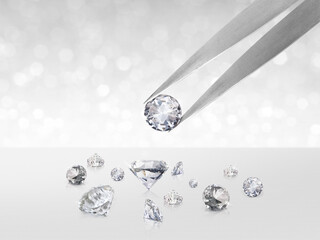 Diamond in tweezers on white shining bokeh background. concept for chossing best diamond gem design
