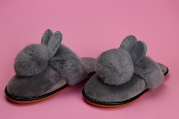Slippers with fluffy ears, comfortable women's home shoes on a pink background
