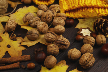 Autumn composition of yellow leaves and nuts on a wooden table background