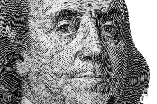 United States hundred dollars money bill closeup. Portrait of US president Benjamin Franklin on 100 dollars banknote macro fragment.