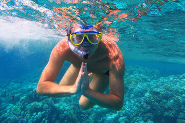 Fototapeta premium Underwater shot. Man diving with scuba in a tropical sea. Travel lifestyle, outdoor water sport adventure, swimming lessons on summer beach vacation