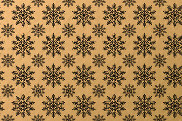 A seamless Christmas background illustration of black snowflakes against a gold background
