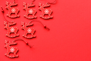 White and red wooden Christmas tree decorations on a red background with place for text