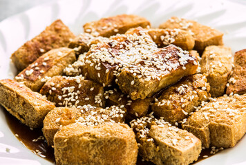 Fried tofu with tamarind sauce and sesame in plate , Asian food.