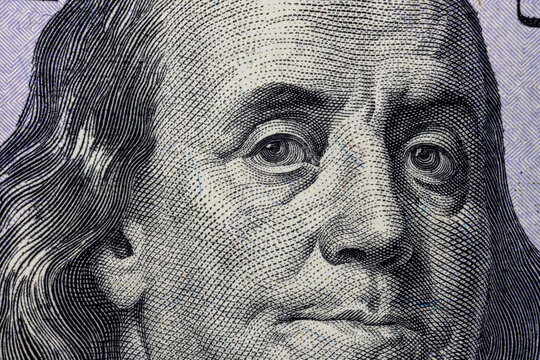 United States hundred dollars money bill closeup. Portrait of US president Benjamin Franklin on 100 dollars banknote macro fragment.