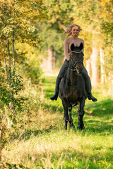 Beautiful girl riding a horse riding without a saddle in a autumn forest