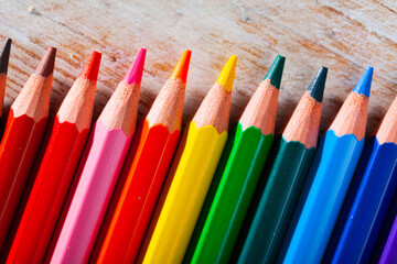 Closeup of colored lead pencils for drawing on wooden surface..