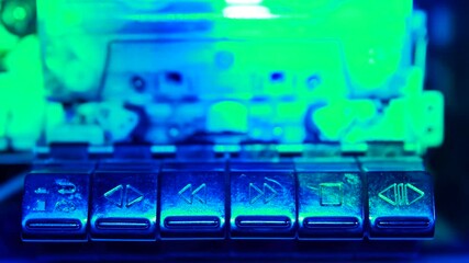 Retro cassette tape deck recorder. Finger pushing play and rewind buttons and the playback controls the audio player.