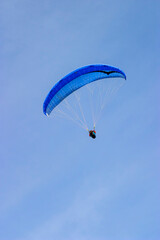 Paraglider flying at a clear blue sky