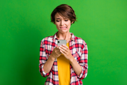 Photo of worried person bite lip look screen oops mistake plaid clothing isolated on green color background