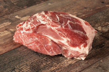 Raw pork meat on dark wooden rustic background. Piece of raw meat ready for preparation