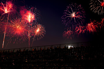 double exposure of fireworks and celebrating with the silhouette of people