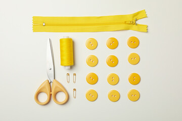 Yellow sewing supplies on white background, top view