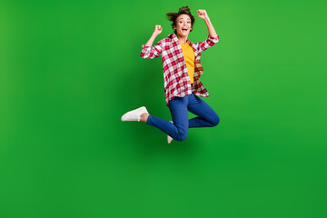 Full size profile photo of impressed sweet girl jumping hands fists wear trousers shirt sneakers isolated on green color background