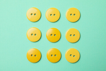 Flat lay with yellow buttons on mint background