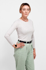 Portrait of a young woman with short hair. In a white sweater and green trousers.