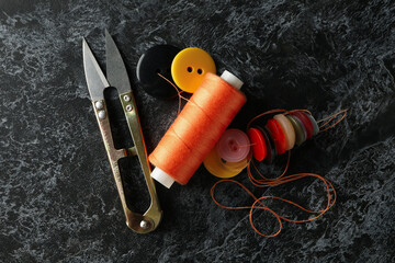 Sewing supplies on black smokey background, top view