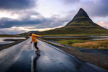 Action shot of a skater on a wet road around mount Kirkjufell in Iceland