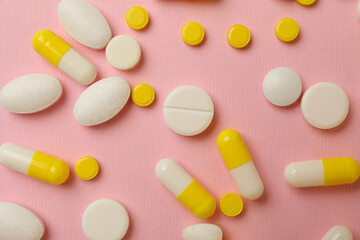 Different pills on pink background, top view