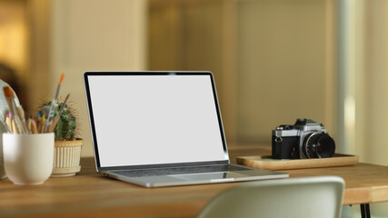 Workspace with laptop, camera and decorations on wooden table, clipping path