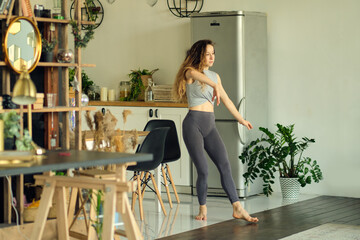 millennial girl wearing have fun moving listening to music relax in living room, happy young woman...