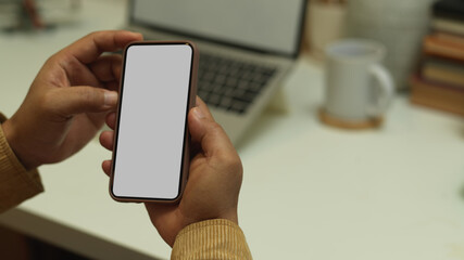 Male hands using smartphone while sitting at workplace, clipping path