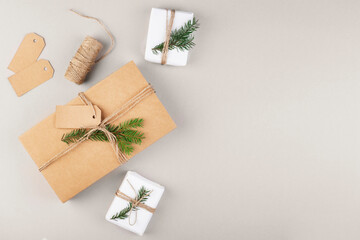 Fototapeta na wymiar gifts in craft paper, eco-friendly packaging of Christmas gifts, gray background, top view