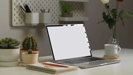 Side view of worktable with laptop, stationery, mug and decorations, clipping path