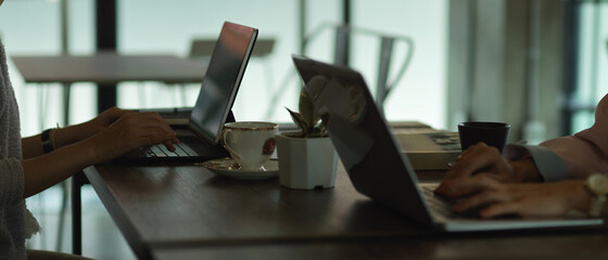 Worktable win cowering space with two people working with laptop