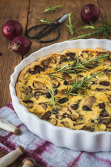 Vegetarian mushroom tart with red onions and rosemary on wooden table. Vertical stock photo.