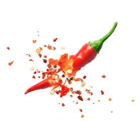 Foto auf Acrylglas Scharfe Chili-pfeffer Chiliflocken platzen aus roter Chilischote auf weißem Hintergrund