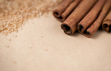 Cinnamon sticks with brown sugar on light background with blank text space